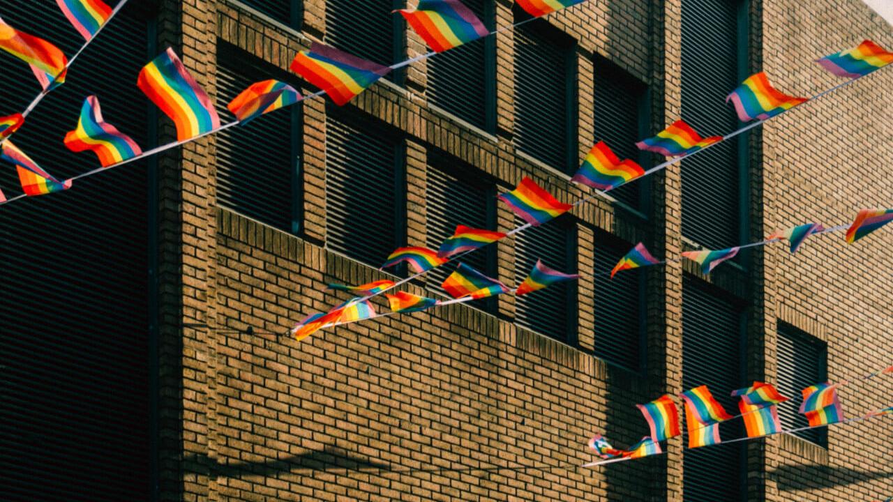 Mehrere Regenbogenfahnen wehen vor einem Haus