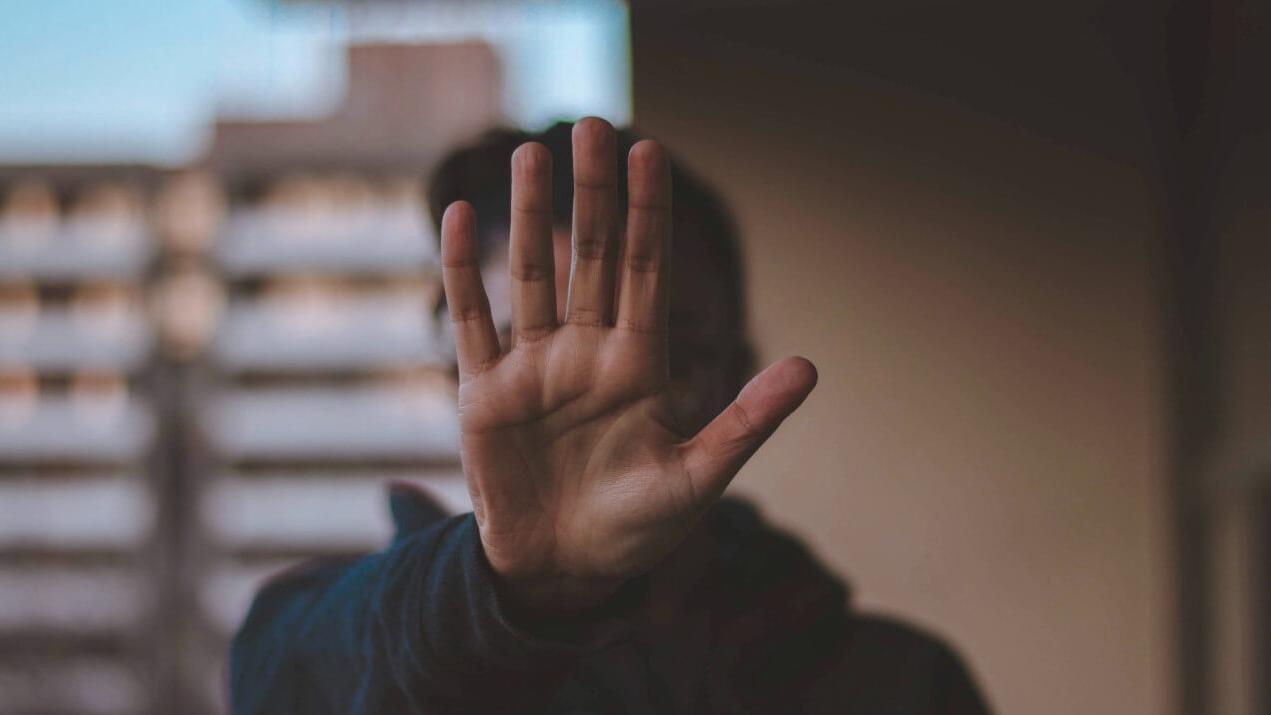 Innenministerkonferenz soll sich endlich mit homophober und transfeindlicher Gewalt beschäftigen Person hält Hand als Stoppzeichen in die Kamera