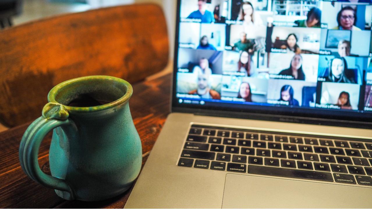 Kaffeetasse und Laptop mit einer Videokonferenz
