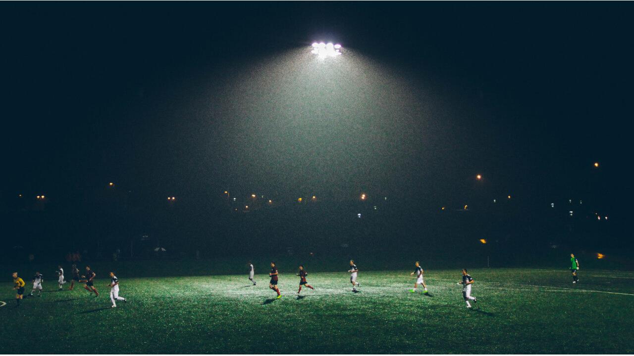 Fussballspiel im Flutlicht: Symbolbild für Regenbogenkompetenz im Fussball
