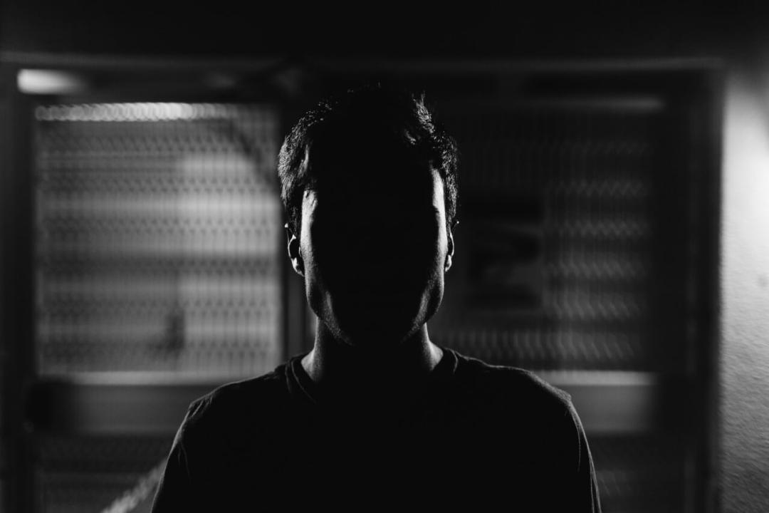 Mann mit Gesicht im Dunkeln. Symbolfoto für den Bericht: Abschiebung von schwulen Mann verhindern