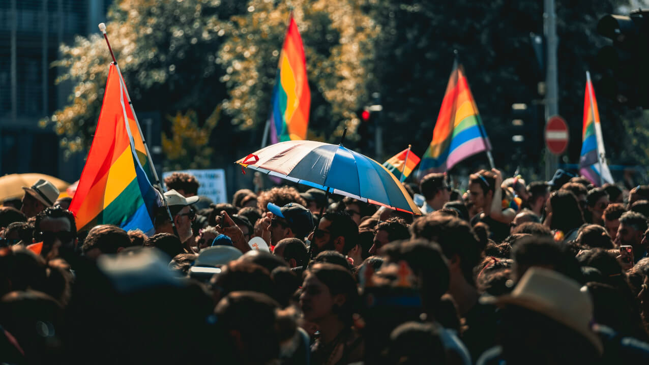 Fünf Forderungen zum IDAHOBIT 2022 am 17 Mai Menschenmenge mit Regenbogenfahne. Fünf Forderungen zum IDAHOBIT 2022 am 17 Mai
